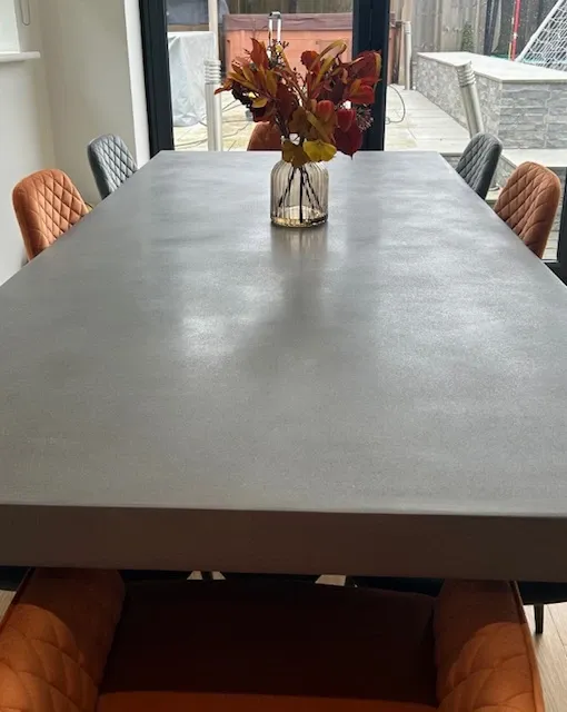 Sculptural polished concrete dining table with architectural profile and welded steel base