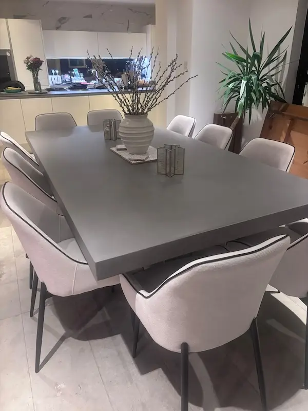 Large polished concrete dining table seating ten to twelve on welded steel base