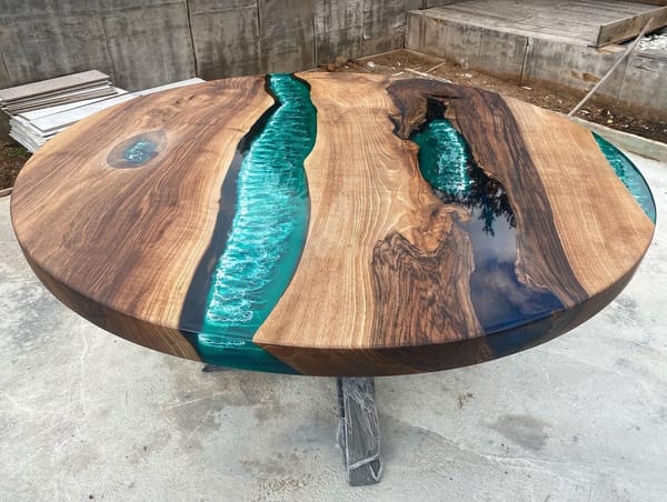 Handcrafted round resin river dining table with natural timber grain and steel pedestal base